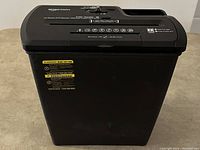 Full view of Amazon Basics shredder from the front showing black base and upper section with paper slot.