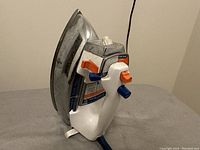 Side view of the GE clothing steam/dry iron showing the stainless steel soleplate and adjustment lever.