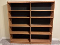 Front view of two adjacent bookcases showing shelves and backing