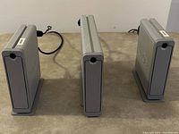 Front view of three grey LaCie d2 external hard drives placed side by side, standing vertically.