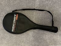 Protective black cover for Yamaha Secret 06 tennis racquet with branded text and carrying strap