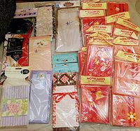 Full view of vintage note cards and magnetic list pads in original packaging, showing variety of floral and decorative designs.