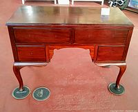 Front view of vintage cherry wood dresser table with three drawers and Queen Anne cabriole legs.
