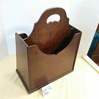 Front angled view of the vintage wood book and magazine holder displaying the curved handle and divided design.