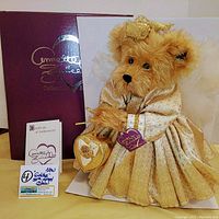 Goldie 50th Angel Bear with gold dress, wings, heart-shaped box, certificate and purple box