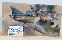 Front box art showing Spitfire MK IXC model aircraft in flight with painted camouflage and markings, along with auction label on front.