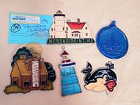 Overview of five stained glass collectibles including lighthouse, house thermometer, whale, and blue oval piece