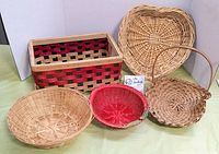Full lot of five vintage woven baskets visible, showing rectangular basket with red and black woven strips, heart shaped and round natural baskets, and small red basket.