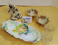 Overall view of porcelain dishes, glass candle holders, and ceramic figurine