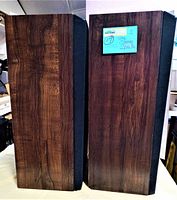 Two vintage Sansui stereo speakers with wood grain vinyl finish shown side-by-side.