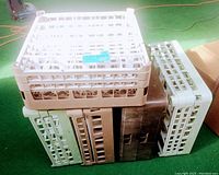 Five stacked vintage commercial dishwasher racks in white and brown plastic. Clearly shows the dimensions and different colors.