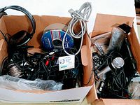 Box with assorted audio wiring spools, cables, car chargers, and miscellaneous items