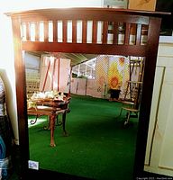 Front view of the vintage wood framed mirror showing the vertical slat design on the upper section of the frame.