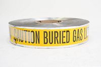 Photo showing full roll of yellow caution tape with black text "CAUTION BURIED GAS LINE BELOW"