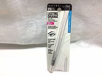 Front view of packaged Maybelline Lasting Drama Automatic Pencil in shade 810 White Luster. Shows product in plastic blister packaging with cardboard backing detailing product name and features.
