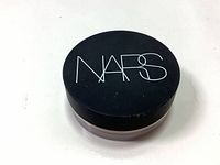Closed top view of round black plastic container with NARS logo on lid.