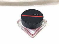 Top view of the blush container showing black lid with red stripe and Shiseido logo.