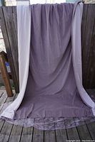 Curtain opened and draped neatly showing mauve velvet fabric and size