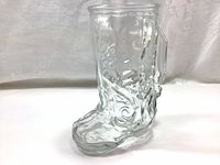 Front angled side view of the thick glass cowboy boot shaped beer pint glass with embossed details.