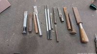 Full assortment of coal chisels and punches laid out showing variety in size and handle type.