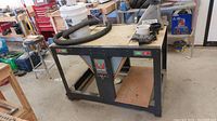 Full view of Craftsman rotary tool bench with metal frame and wooden surface in workshop.