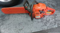 Full side view of chainsaw with orange bar cover installed