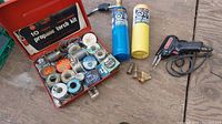 Full overview of propane torch kit contents, solder wire spools and canisters on wooden background
