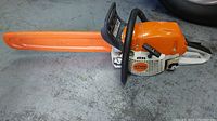 Chainsaw in scabbard on workshop floor