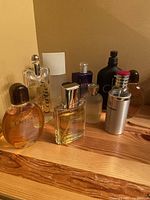 Wide view of nine cologne bottles on wooden surface
