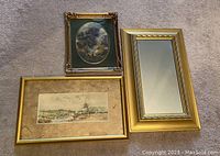 Three gold gilt framed items, including oval oil painting, rectangular gold framed mirror, and rectangular framed landscape artwork, arranged on carpet.
