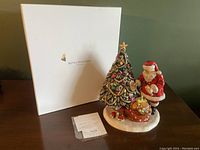 White Royal Doulton branded box behind figurine and paperwork on table