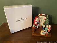 Photo of the Royal Doulton white original box alongside the Santa's Toy Testing figurine on a wooden surface