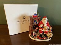 White Royal Doulton box displayed behind the figurine