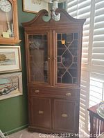 Full view of walnut china cabinet showing closed glass doors, drawer, and lower cabinet doors
