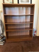 Front view of the wooden bookshelf showing all shelves and overall condition.