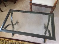 Coffee table showing the metal frame and textured glass top from above.