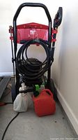 Full front view of power washer, hose, spray gun, gas can and jug