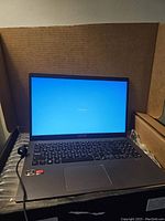 Front view of open laptop showing screen and keyboard in packaging