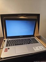 Laptop open showing display, keyboard and power cable connected