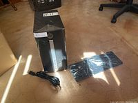 Overview of HP tower, power cord, keyboard, and mouse on floor