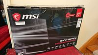 Front of original box showing MSI logo, Optix G27C4 branding, 27″ size and curved gaming monitor label