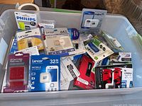 Bin of assorted sealed USB drives, SD and microSD cards