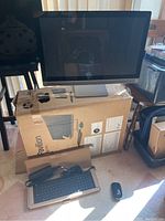 Monitor on original HP box with keyboard, mouse and power adapter arranged in front