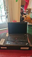 Front view of ThinkPad X230 open on its box