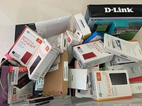 Pile of boxed portable drives, cables and accessories on table
