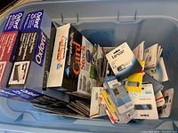 Box containing various USB flash drives, micro SD cards, and cardstock and folders.