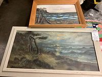 Two framed art pieces on board showing landscape/water scenes with signature LVH