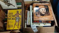Box of books including 'The New World', 'Vanishing Cultures of South Africa' and other art-themed books.