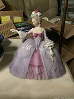 Front view of Franklin porcelain figurine representing Marianne the Minuet in pastel pink and mauve dress with extended arm and fan.