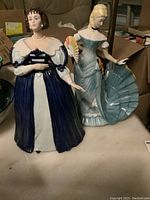 Two Franklin porcelain statues displayed together, Henrietta the Pavane and Arabella the Waltz, showing size and styling.